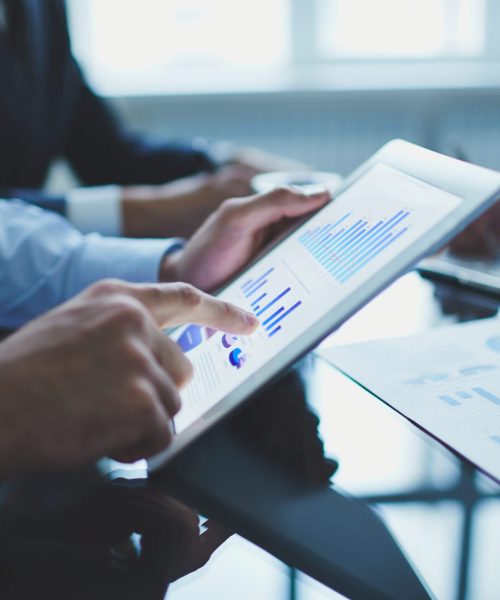 Image of businessperson pointing at document in touchpad at meeting