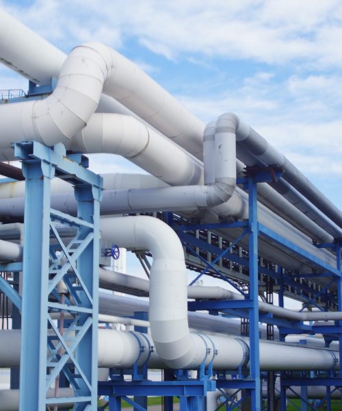 A closeup of industrial pipelines around a factor on a sunny day